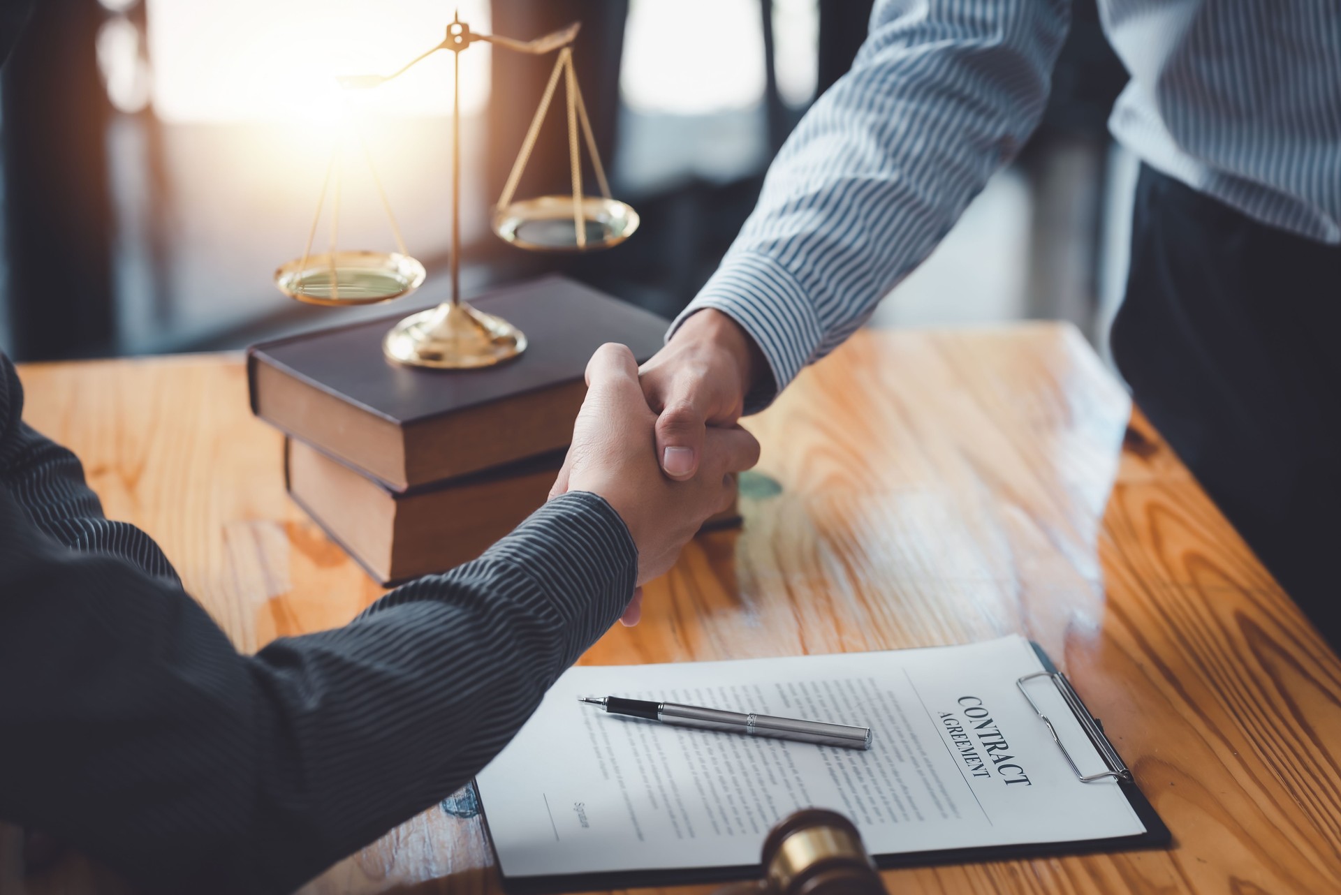 Businessman shaking hands partner lawyers or attorneys discussing a contract agreement.